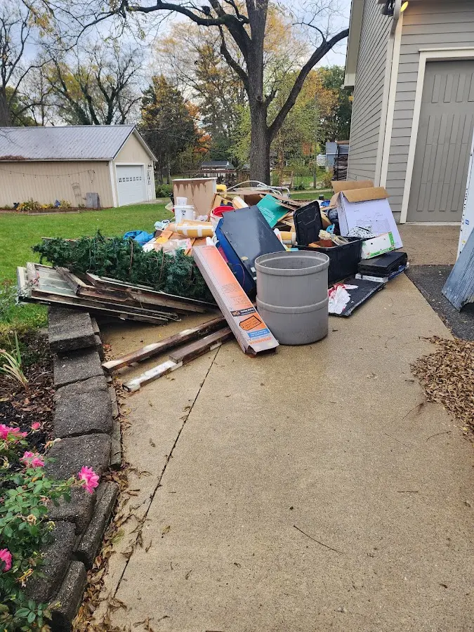 Dumpster being loaded with debris for Estate Cleanout Dumpster Rental in Pelham